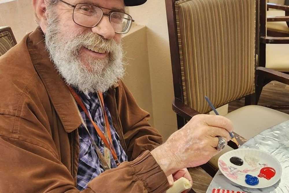 Resident painting at Woodland Palms Memory Care in Tucson, Arizona