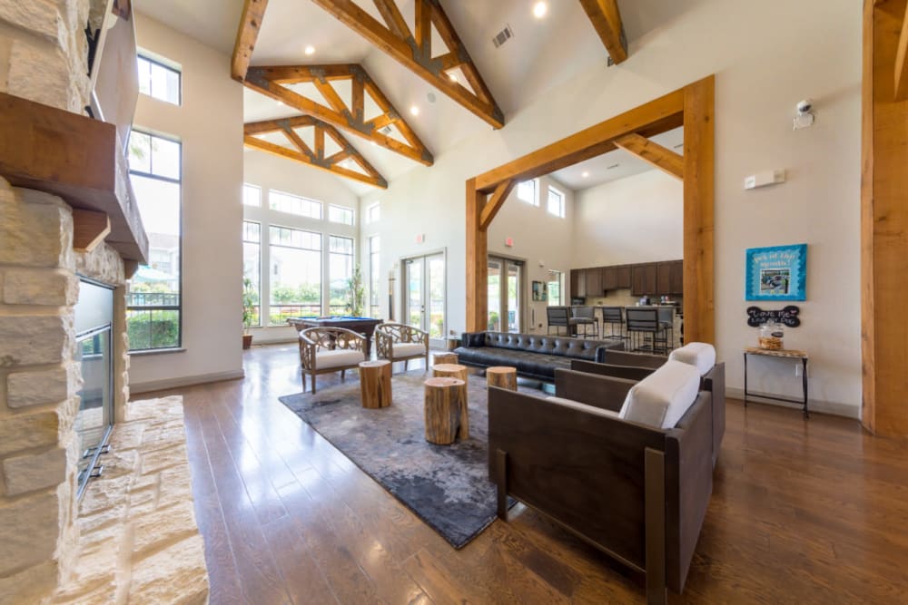 Community clubhouse sitting area with stone fireplace overlooking dining area at Marquis at Sugar Land in Sugar Land, Texas