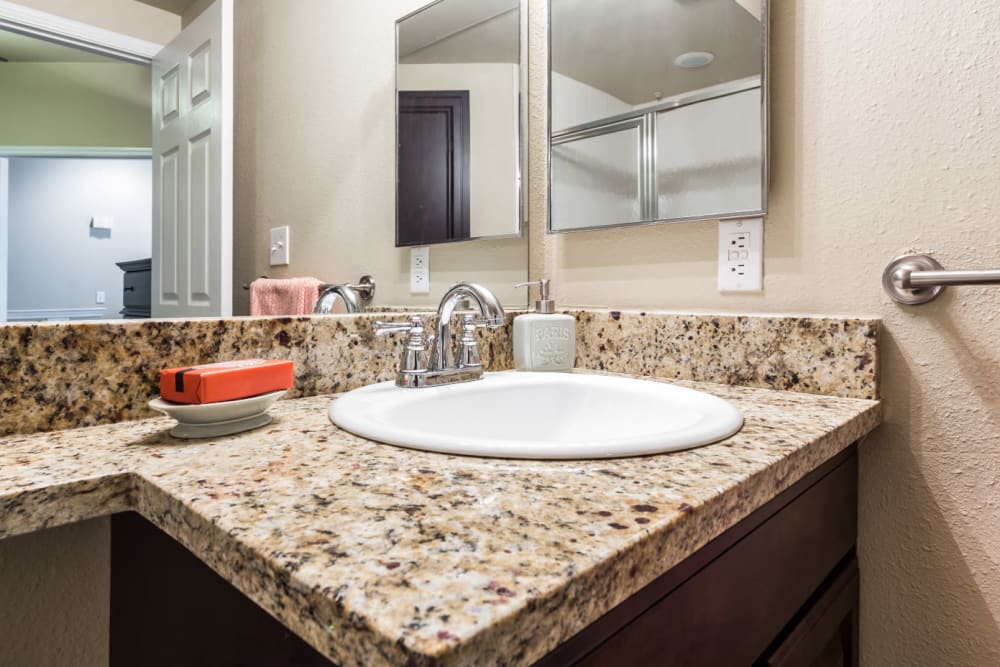Bathroom sink with granite counter at Marquis at Stonegate in Fort Worth, Texas