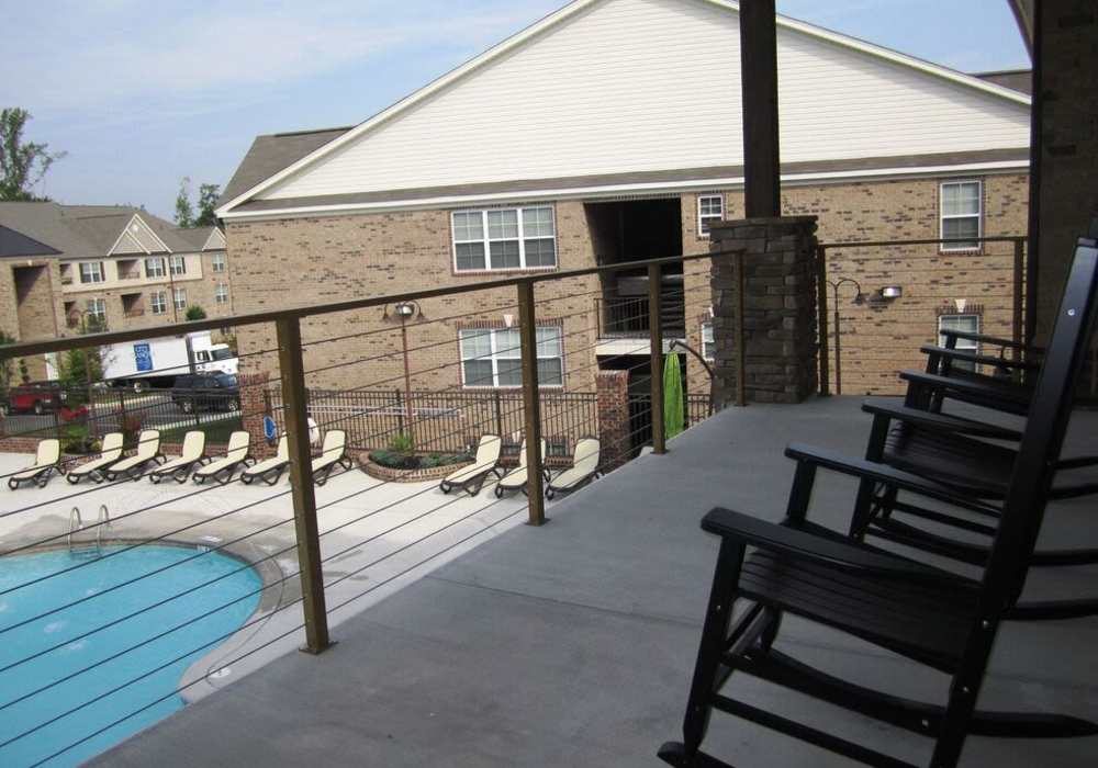 View of pool from cabana with rocking chairs.