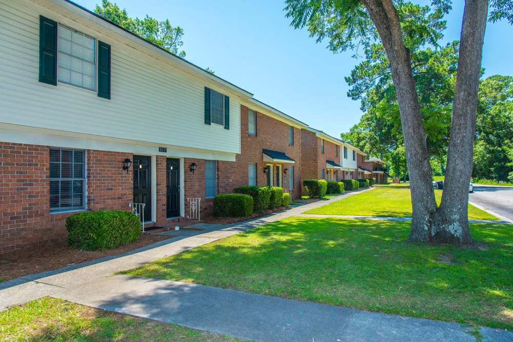 Side exterior view of the apartment with path ways and lush green at Magnolia Downs in Charleston, South Carolina