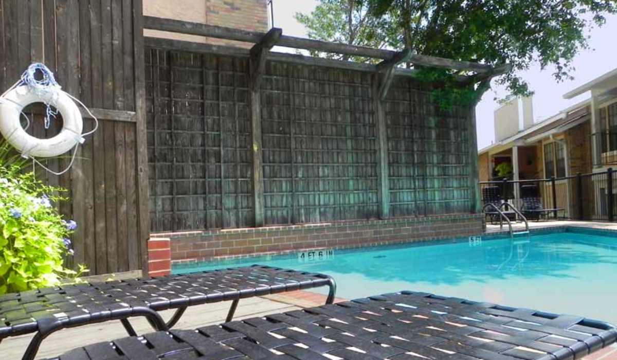 Swimming pool surrounded by lounge chairs at Highcrest in San Marcos, Texas