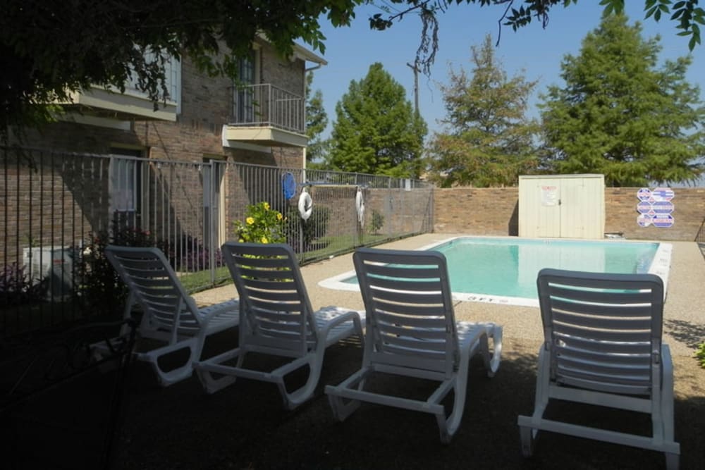 Lounge chairs and pool with storage on deck at Highlands of Grand Prairie in Grand Prairie, Texas