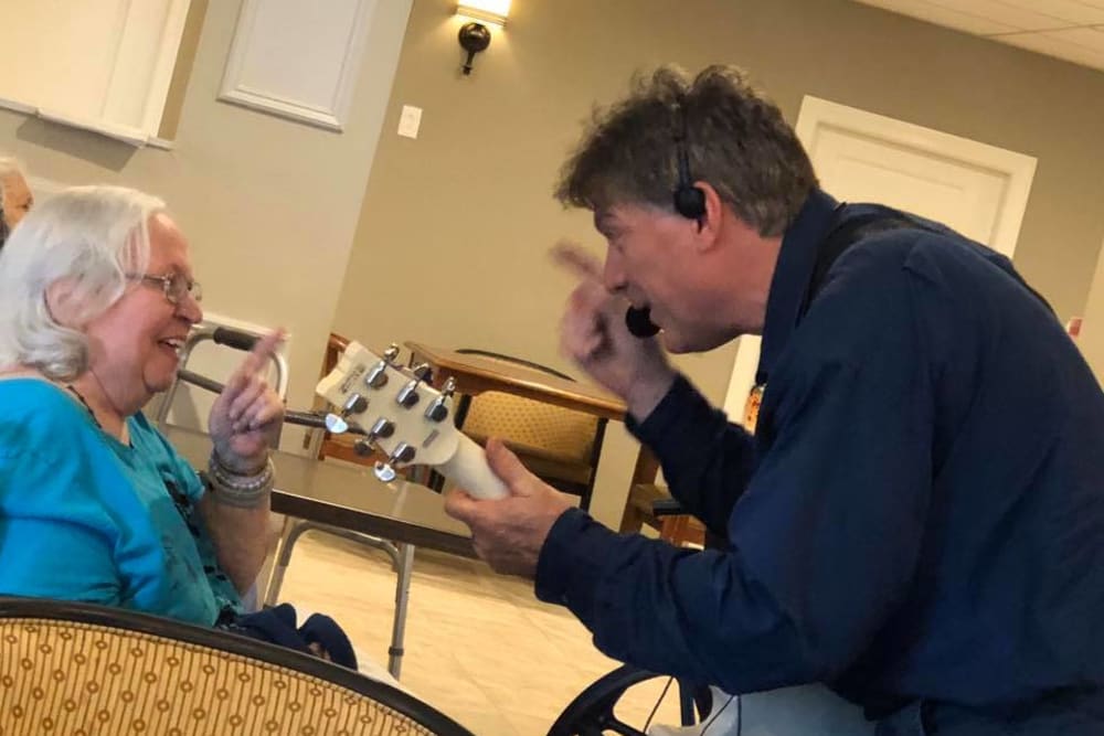 A staff member singing to a resident at Inspired Living Sun City Center in Sun City Center, Florida.