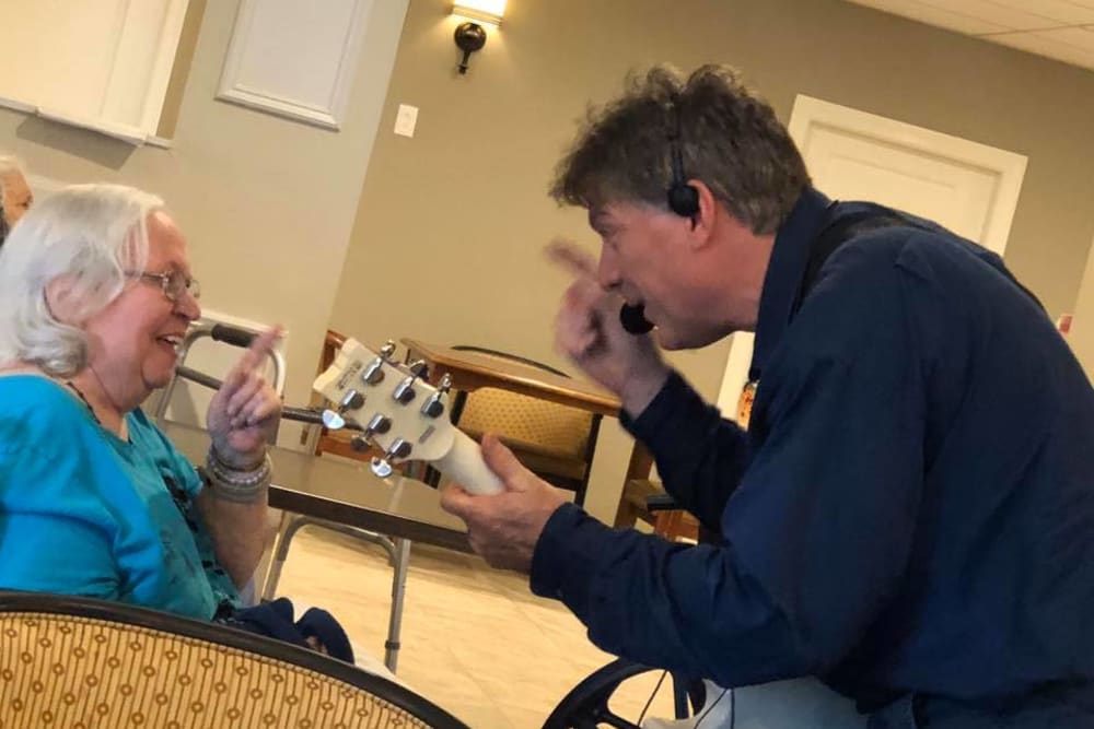 A staff member singing to a resident at Inspired Living Sun City Center in Sun City Center, Florida. 