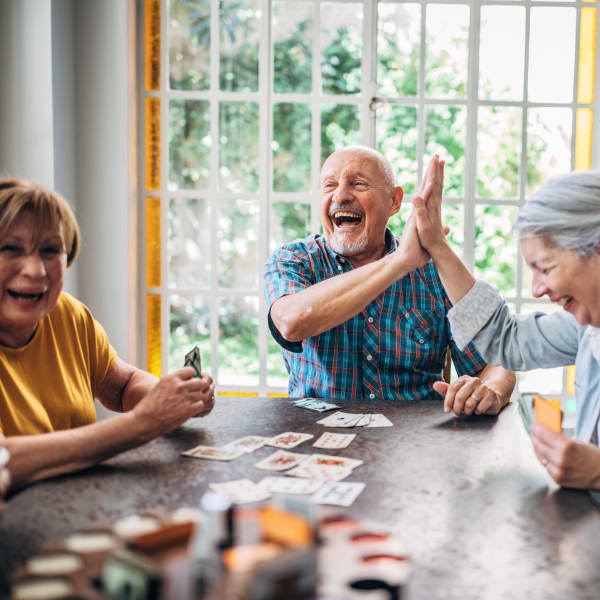 Three residents playing a card game at Alta Vista Senior Living in Vista, California