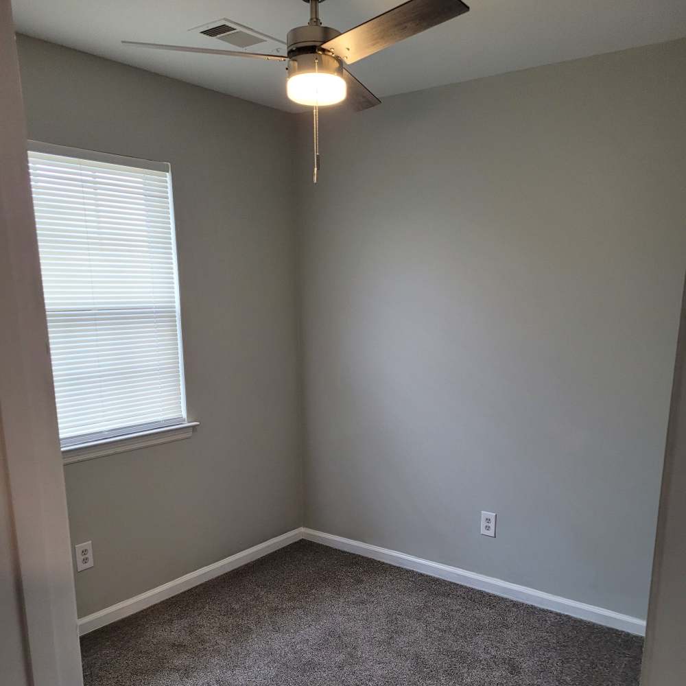 Bedroom with a window and ceiling fan at Maple Manor Apartments in Lebanon, Tennessee