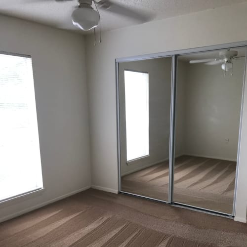 Apartment bedroom with a ceiling fan at Arbors on 31st in Bryan, Texas