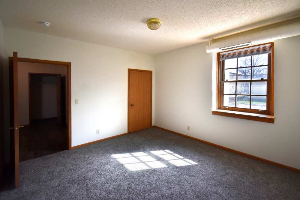 Spacious room with natural light and carpeted flooring at Bottineau Commons & Lofts in Minneapolis, Minnesota