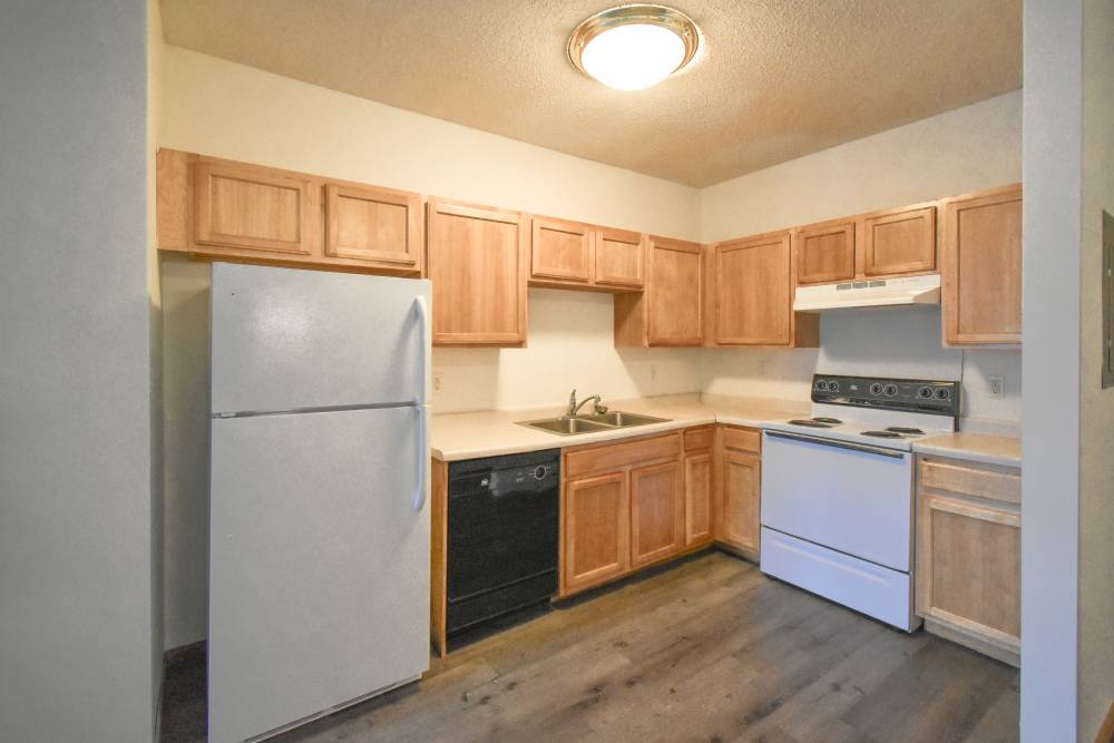 Fully-equipped kitchen with wood-style flooring and at Bottineau Commons & Lofts in Minneapolis, Minnesota