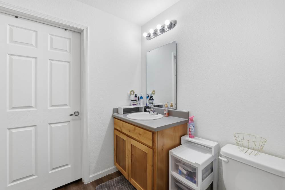 Cozy bathroom featuring a sleek sink vanity and modern lighting at Flats At Sam Lane in Ringgold, Georgia.