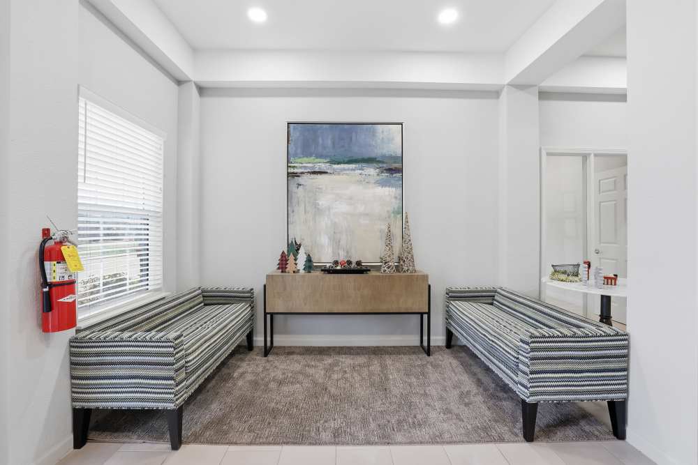 Bright and inviting foyer featuring stylish seating and contemporary art at Flats At Sam Lane in Ringgold, Georgia.
