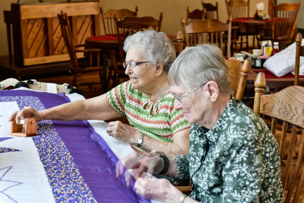 Two residents sewing a quilt together at Garden Place Red Bud in Red Bud, Illinois