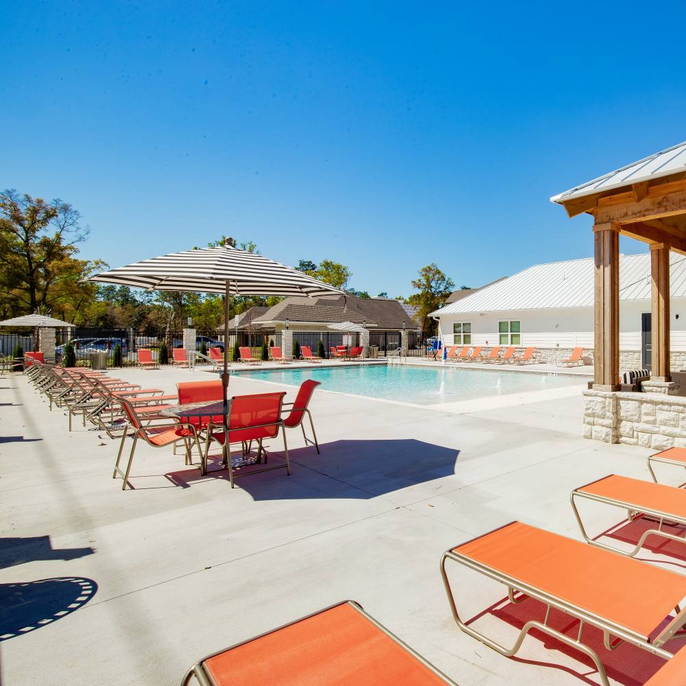 Resort-style swimming pool with lounge beds at Retreat at Redstone in Crestview, Florida