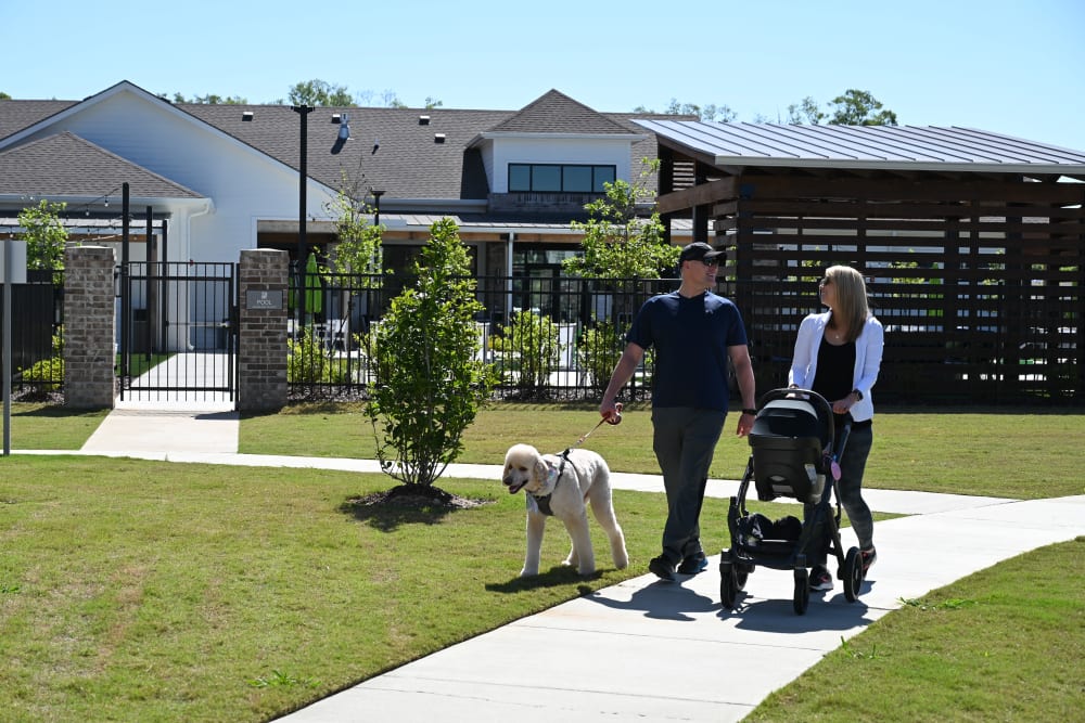 A family and their dog walking near The Flats at East Bay in Fairhope, Alabama