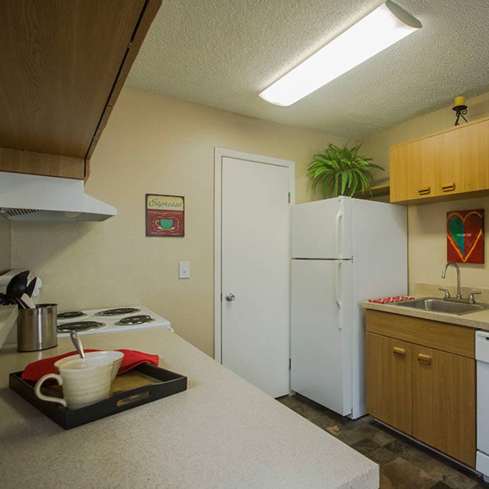 Modern kitchen with warm wood cabinetry and a cozy feel at Park Place Apartments in Port Richey, Florida.
