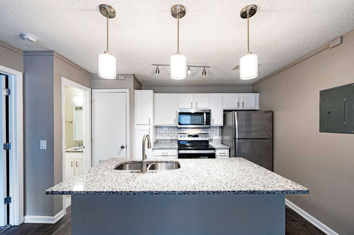 Kitchen with stainless appliances pendant lighting and white cabinets at Avenue at Harbison in Columbia, South Carolina