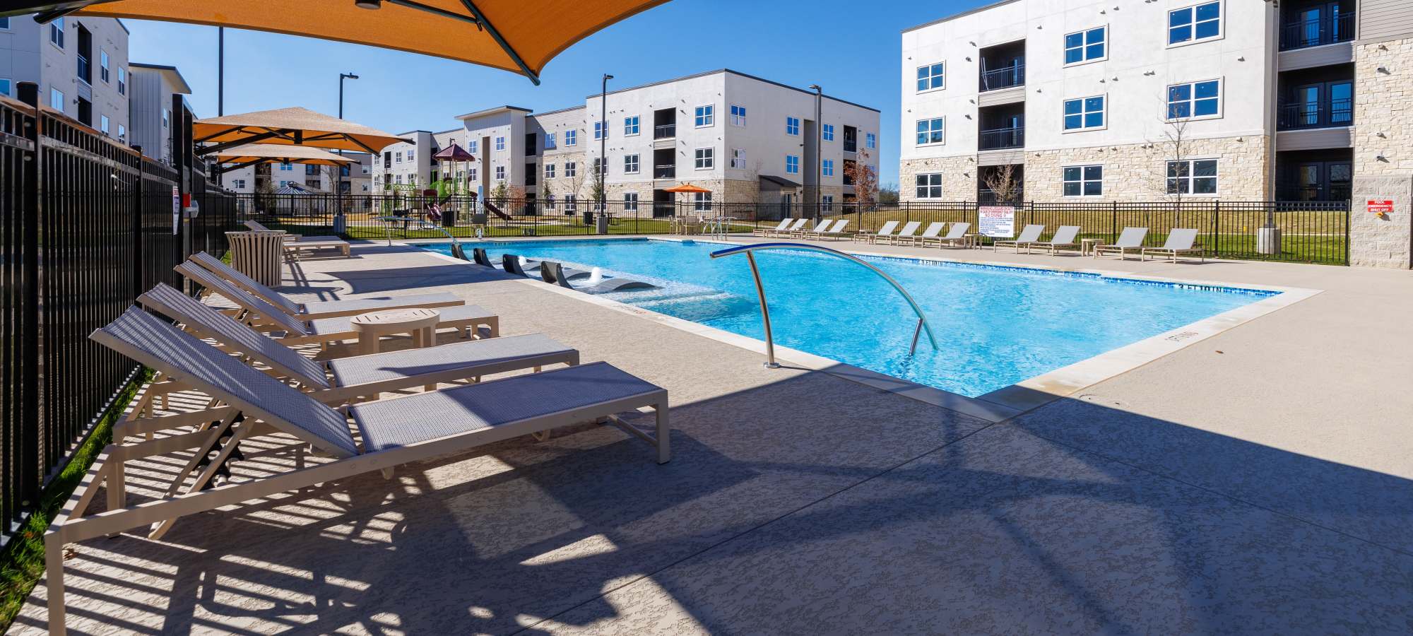 Swimming pool with lounge beds at Walnut Springs in Seguin, Texas