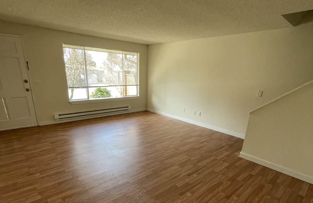 Living room with large window and wood-style floors at Armar Townhomes