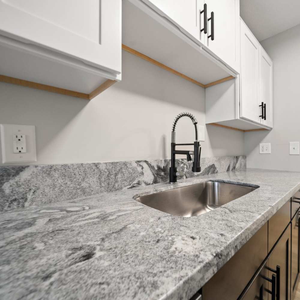 Granite counters and gooseneck faucet kitchen sink at Morada in Crystal, Minnesota