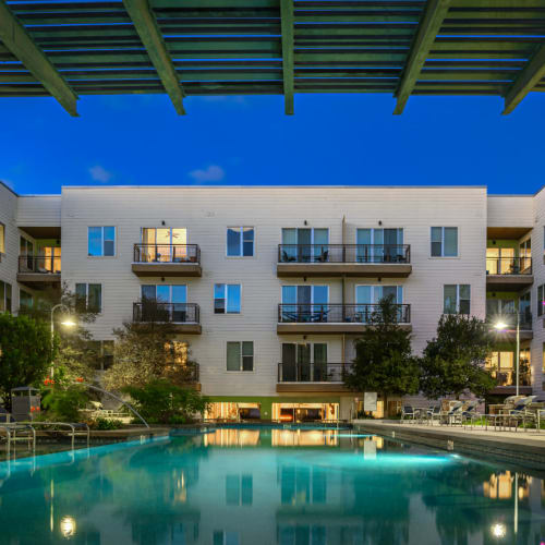 Resort style pool surrounded by lounge chairs at sunset at Sabina in Austin, Texas