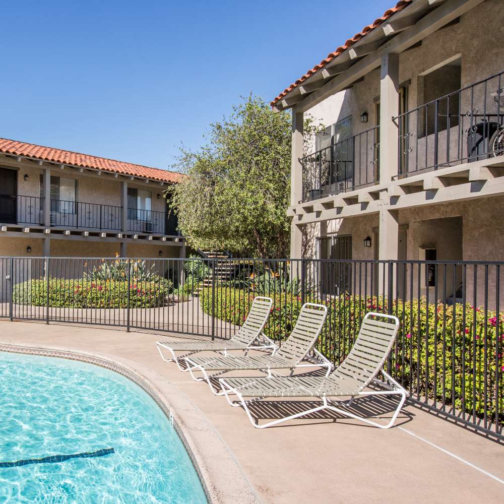 Row of lounge chairs near the swimming pool at Casa Madrid in Cypress, California