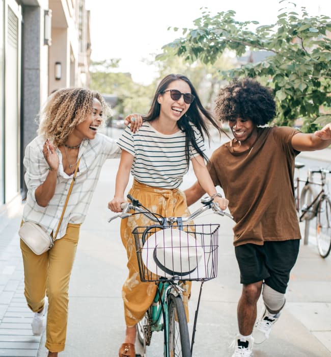 Resident riding bike downtown with two friends alongside her near The Marq at Brookhaven in Atlanta, Georgia