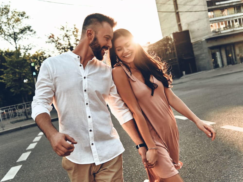 Happy couple holding hands as they take a stroll downtown near Jade Apartments in Las Vegas, Nevada