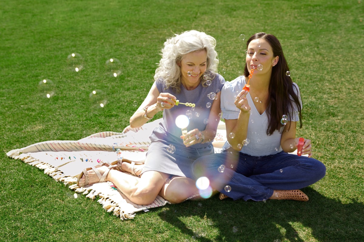 Two residents blowing bubbles in the grass at BB Living at Civic Square in Goodyear, Arizona