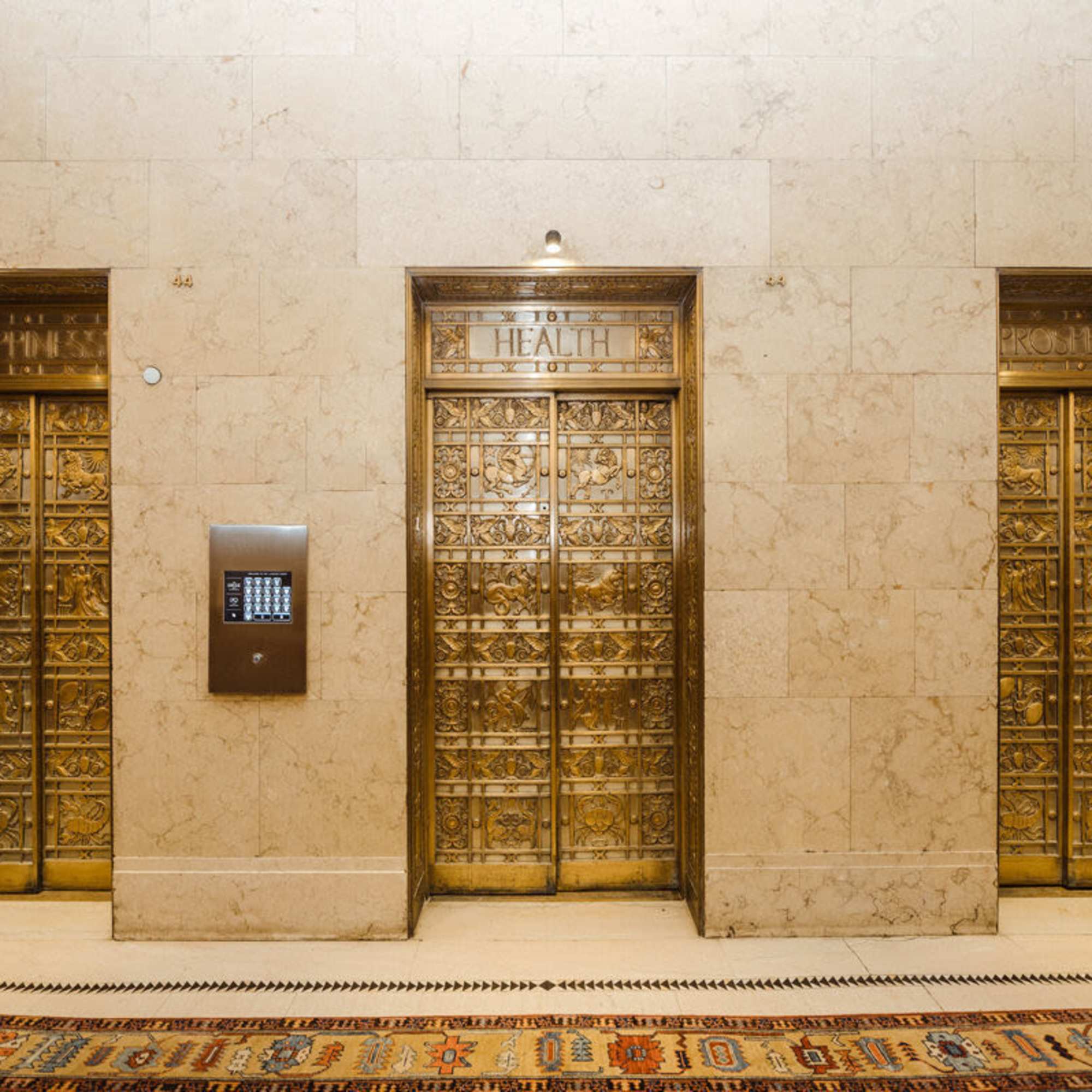 Elegant gold elevator doors in a luxurious marble lobby at LeVeque Tower in Columbus, Ohio