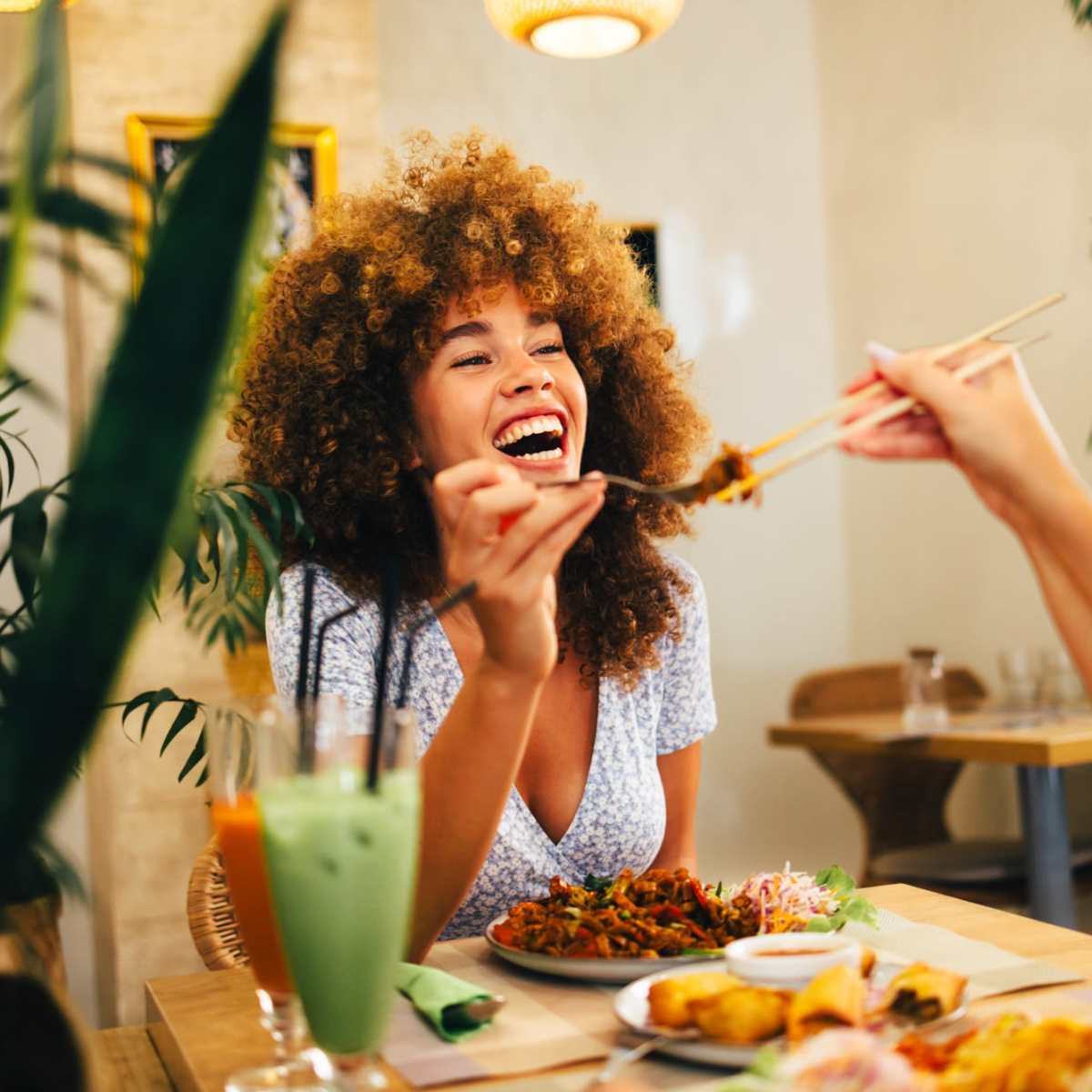 Woman laughing while holding chopsticks at Latitude at South Portland in Portland, Maine