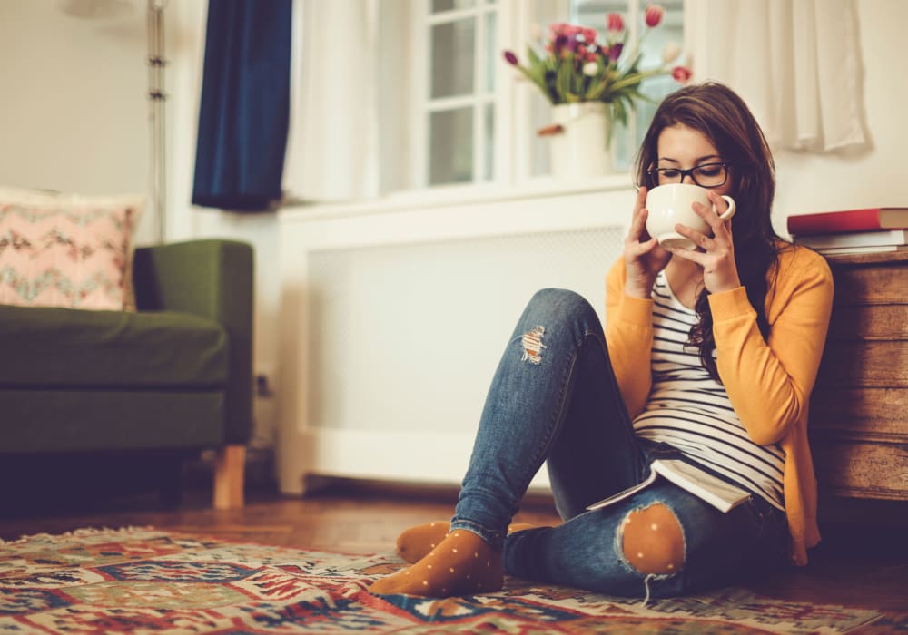 Resident relaxing with a cup of tea in her apartment home at Sofi Redwood Park in Redwood City, California