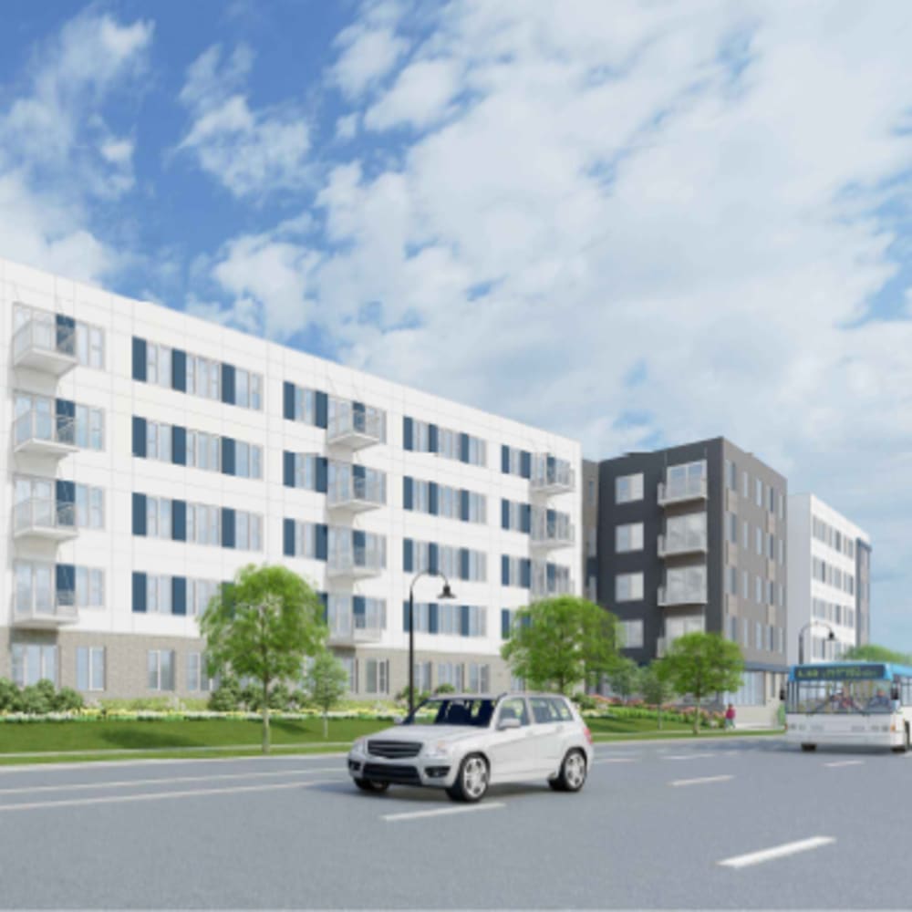 Apartment exterior view and greenery, and vehicles on the road at The Intersect in Madison, Wisconsin 