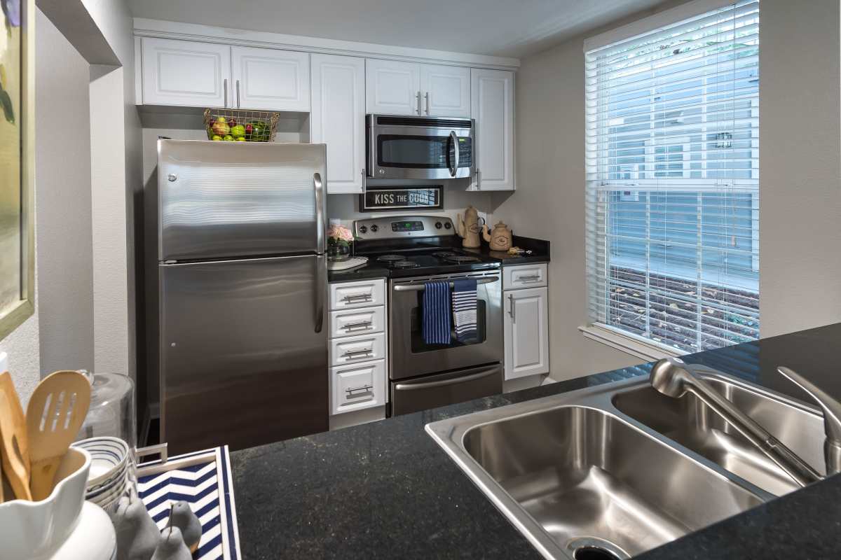 Modern kitchen with stainless-steel appliances and sink at Nantucket Apartments in Santa Clara, California