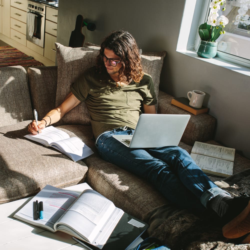 Resident studying in his sunny living room at Briarwood Apartments & Townhomes in State College, Pennsylvania