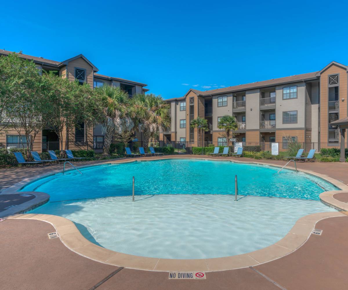 A serene pool with lounge chairs at Edgewater at Klein in Spring, Texas
