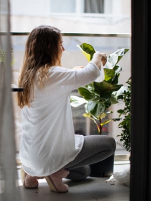 Resident repotting a plant on her private balcony at Argon in Oklahoma City, Oklahoma