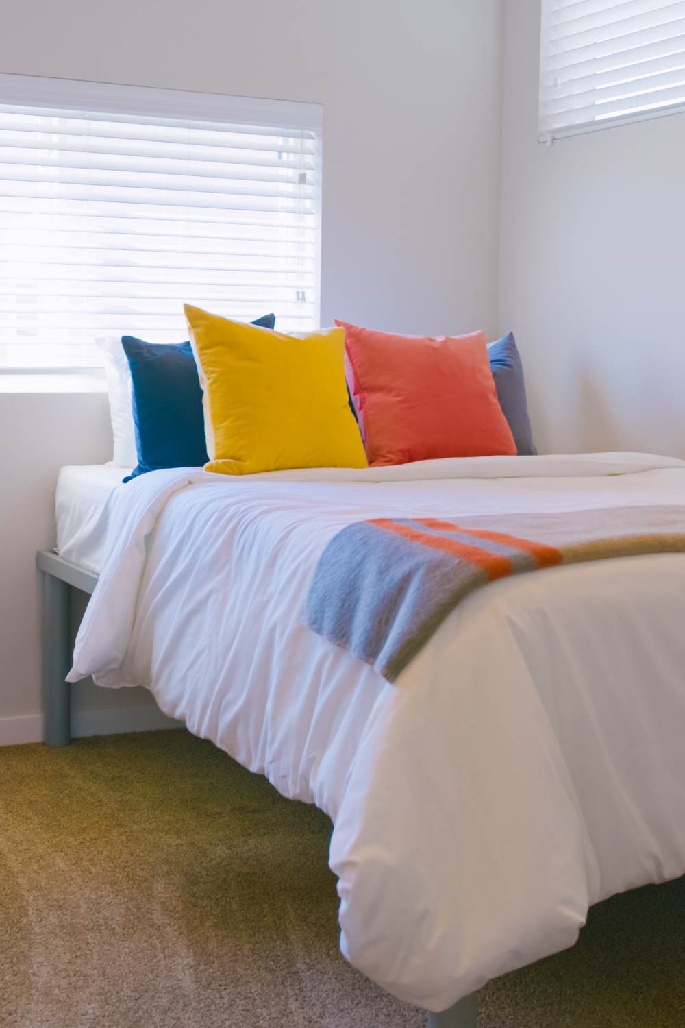 Bed with colorful throw pillows at College Town Fayetteville in Fayetteville, Arkansas