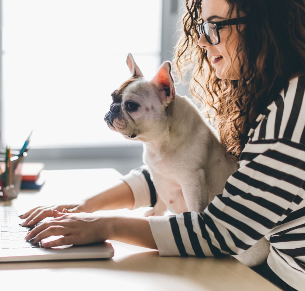 Resident working on her laptop with her dog at Eagle Point Apartments in Tulsa, Oklahoma