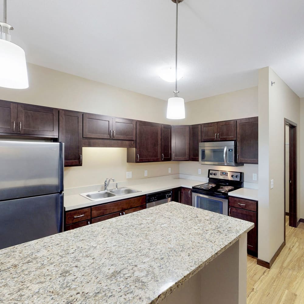 Granite countertops and stainless-steel appliances in a model home's kitchen at Oaks Station Place in Minneapolis, Minnesota