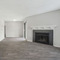 Living room with fireplace and wood-style flooring at Niner Woods in Charlotte, North Carolina 