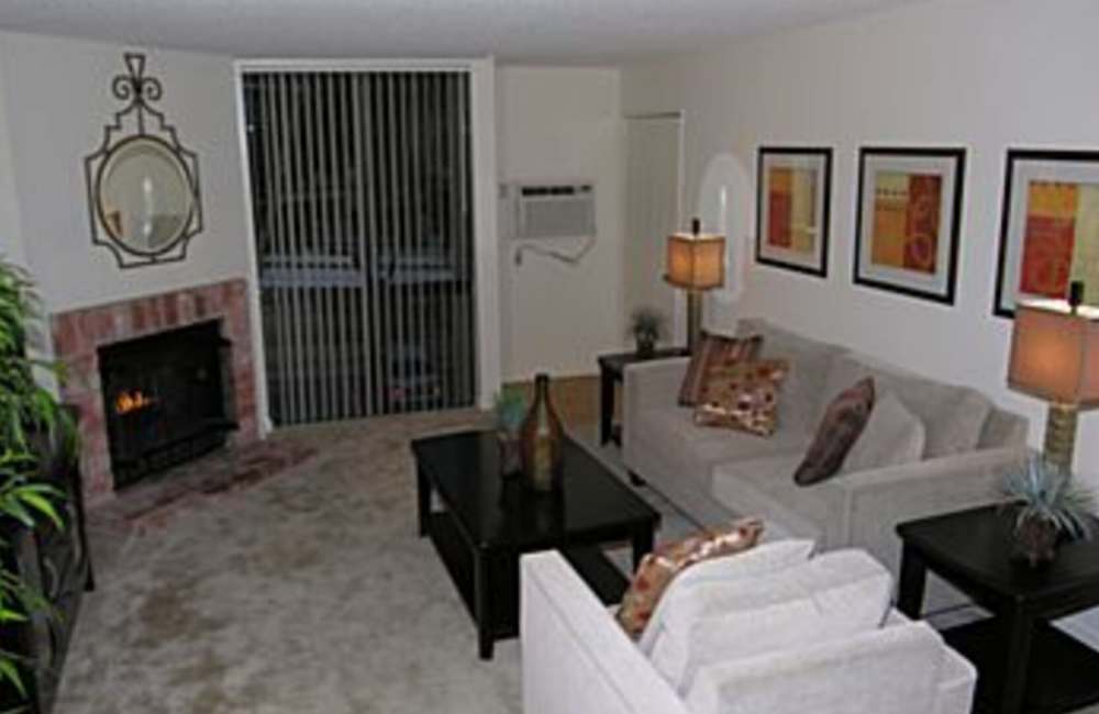 Cozy living room with fireplace as a focal point and comfortable couches at Penasquitos Point in San Diego, California