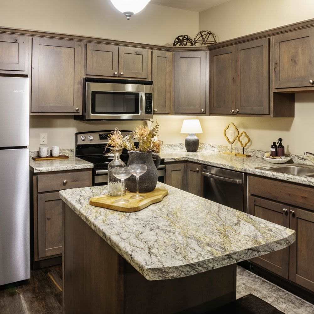 Modern kitchen with wooden cabinets and stainless-steel appliances at InterUrban Apartments in Billings, Montana
