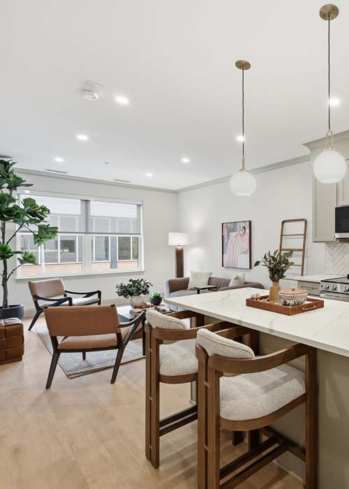 Open-concept kitchen and dining space with island seating and pendant lighting at The Lawrence in Buffalo, New York