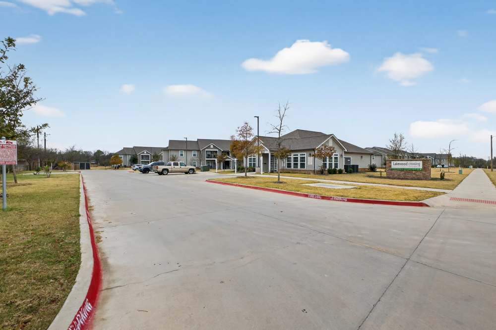 Charming community entrance featuring lush landscaping and modern architecture. Lakewood Crossing in Granbury, Texas.