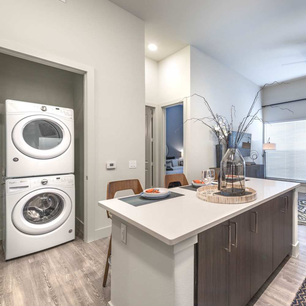 Large kitchen islands beside the washer and dryer area at Hall Street Flats in Dallas, Texas