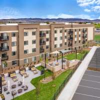 Modern apartment community exterior with balconies and main entrance at WaterWalk Boise - Meridian in Meridian, Idaho