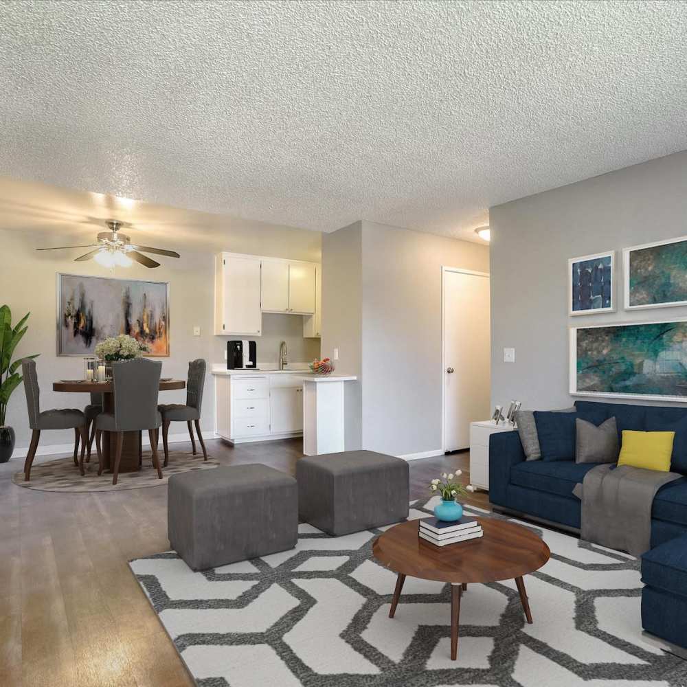 Spacious living room with large couch, chair, coffee table and view to dining area at Santa Teresa Apartments in San Jose, California