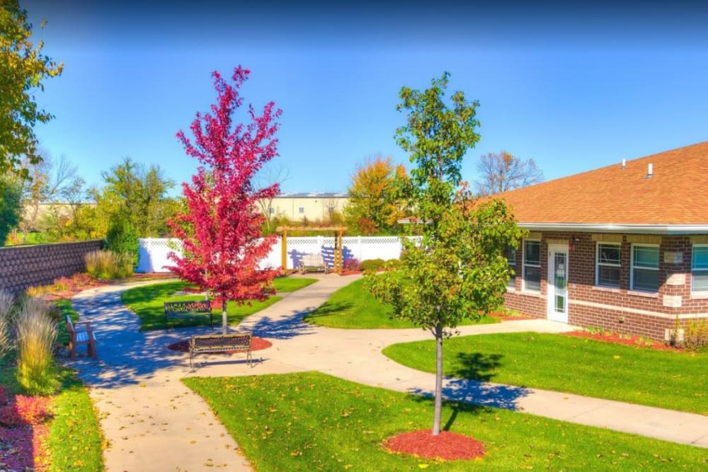 Lush green courtyard with paved courtyard at Addington Place of Ottumwa in Ottumwa, Iowa