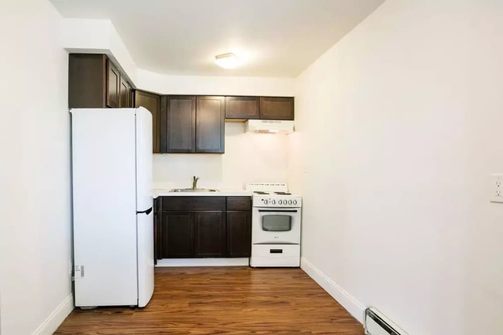 Fully-equipped kitchen with hard-wood style flooring at Detroit Living in Detroit, Michigan
